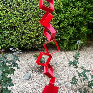Intervals metal sculpture made from stacked hollow steel squares, painted bright red.
