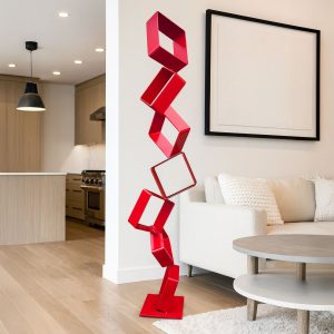 Intervals sculpture with stacked red steel squares displayed in a modern living room.